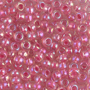 Mostacillas de vidrio japonesas Miyuki calibradas 6/0 transparente con centro de color rosa fuerte o fucsia. Acabado brillante tornasol, ideales para tejido con mostacillas, bordado, aplicaciones costura y bisutería artesanal. Cabeza de Alfiler, Chile.