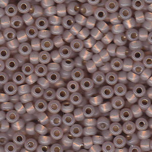 Mostacillas de vidrio japonesas Miyuki calibradas 6/0 de color rosa crema semi transparente con centro dorado. Acabado brillante con centro metálico, ideales para tejido con mostacillas, bordado, aplicaciones costura y bisutería artesanal. Cabeza de Alfiler, Chile.