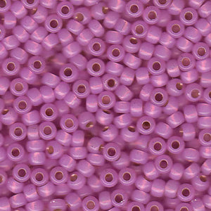 Mostacillas de vidrio japonesas Miyuki calibradas 6/0 de color rosado lila opaco con centro dorado. Acabado brillante con centro metálico, ideales para tejido con mostacillas, bordado, aplicaciones costura y bisutería artesanal. Cabeza de Alfiler, Chile. 