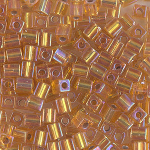 Mostacillas de vidrio japonesas Miyuki calibradas en forma cuadrada de 4 mm de color amarillo ámbar / dorado transparente con centro plateado. Acabado brillante tornasol con centro metálico. Ideales para tejido con mostacillas, bordado, aplicaciones costura y bisutería artesanal. Cabeza de Alfiler, Chile.