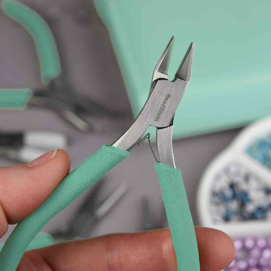 Estuche color aqua abierto mostrando un completo set de 8 alicates y pinzas para bisutería de la marca Beadsmith