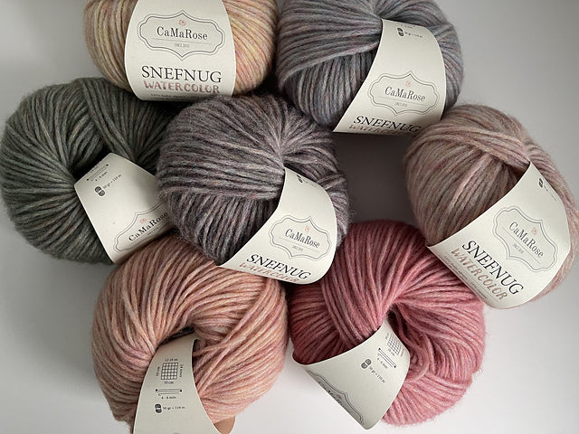 Ovillo de lana soplada Snefnug Watercolor de CaMaRose de 50 gramos, mostrando su textura suave y esponjosa con efecto de color jaspeado acuarela.