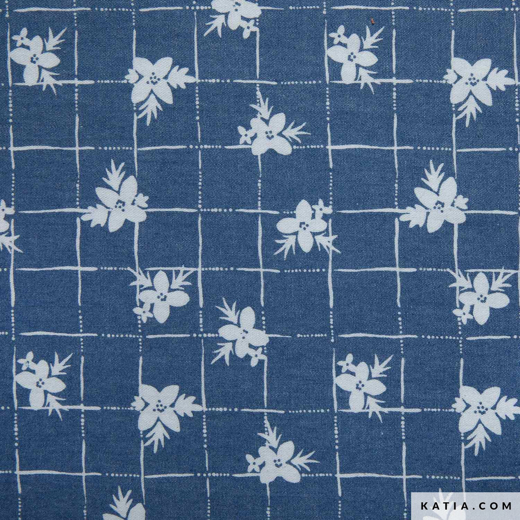 ela 100% algodón de Katia Fabrics con aspecto denim azul claro y un delicado estampado de flores blancas sobre cuadrícula, ideal para coser camisas y vestidos.