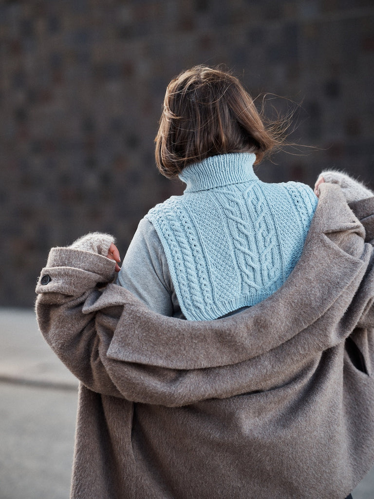 Foundations de Sari Nordlund — chal celeste con trenzas sobre los hombros