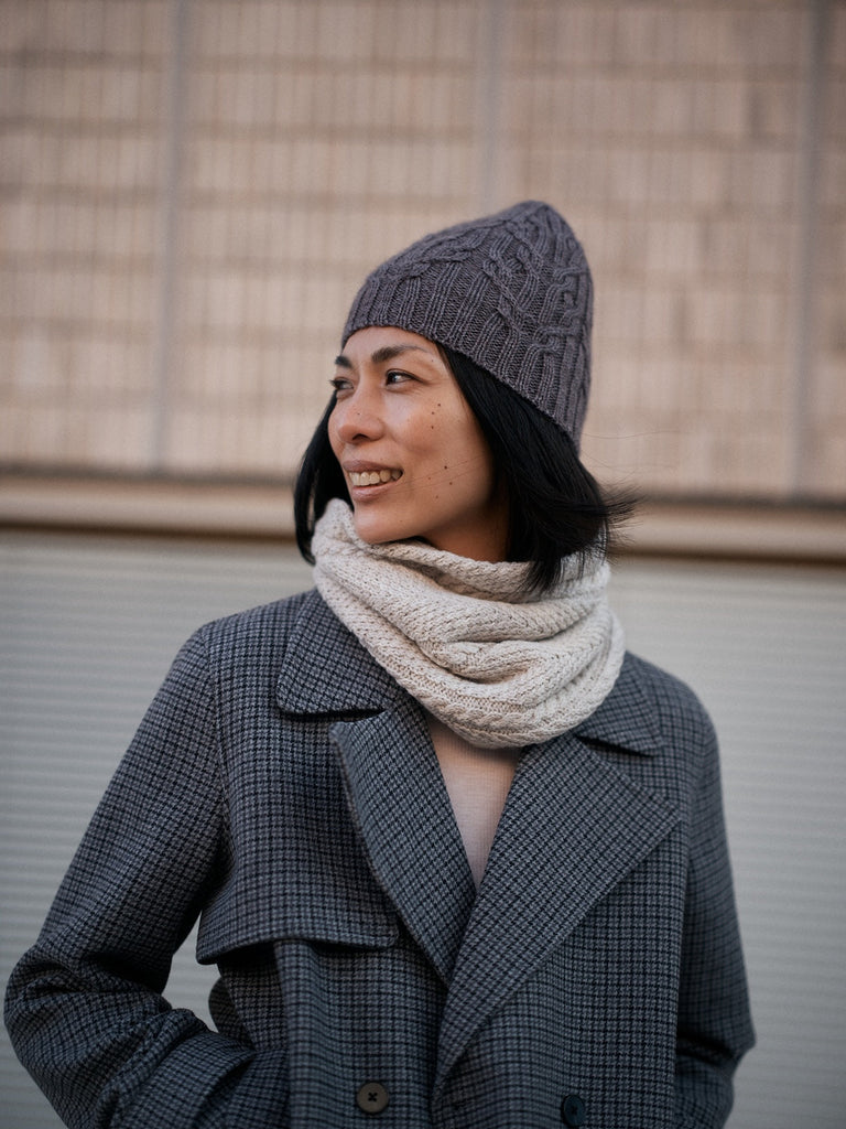 Foundations de Sari Nordlund — gorro gris con textura y cuello circular beige
