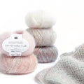 Ovillo de hilado fino Essentials Super Kid Mohair Loves Silk Spray de Rico Design de 25 gramos, mostrando su suave textura peluda y su teñido con motitas de color.