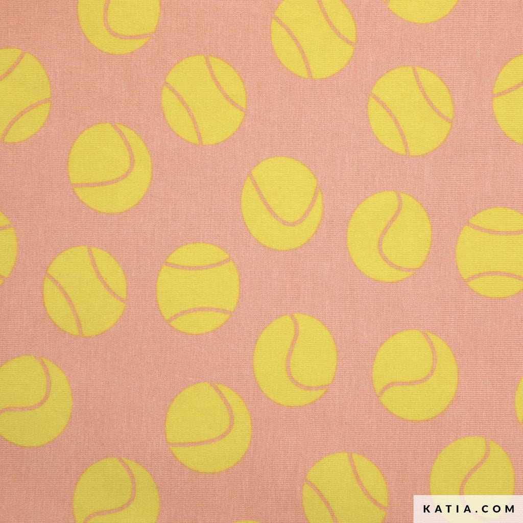 Tela de punto jersey rosada de Katia Fabrics con un llamativo estampado de pelotas de tenis amarillas, ideal para confeccionar ropa deportiva y poleras de verano.