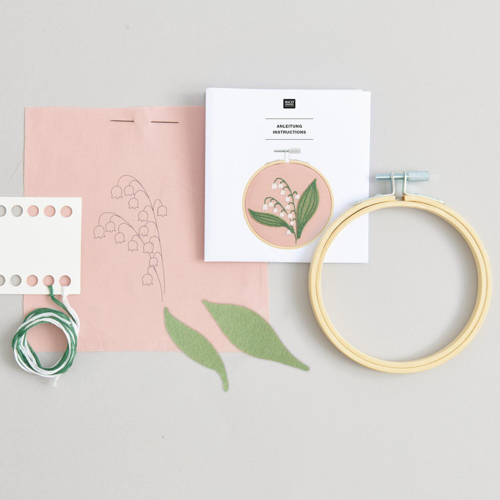 Mini kit de bordado de Rico Design mostrando un delicado diseño de flores Lirios del Valle enmarcado en un bastidor de madera de 10 cm.