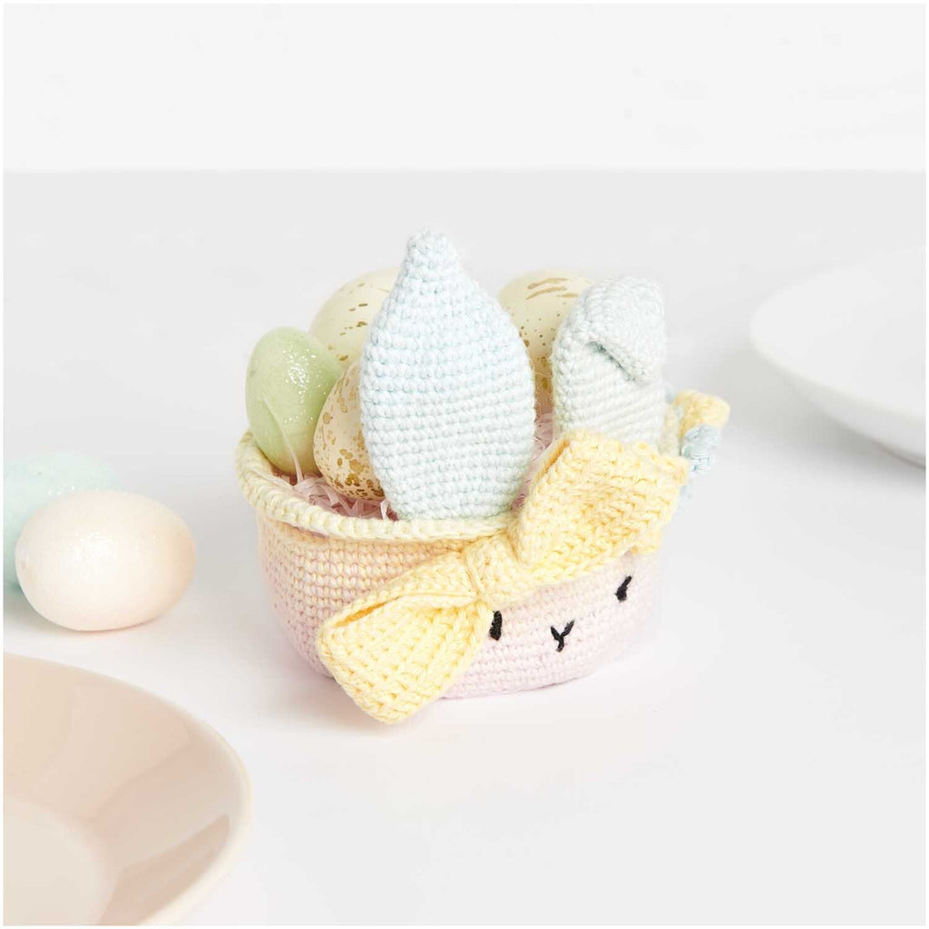 Caja del kit de tejido amigurumi de Rico Design mostrando un pequeño canastito de Pascua tejido a crochet con orejas de conejo y huevitos en tonos pastel.