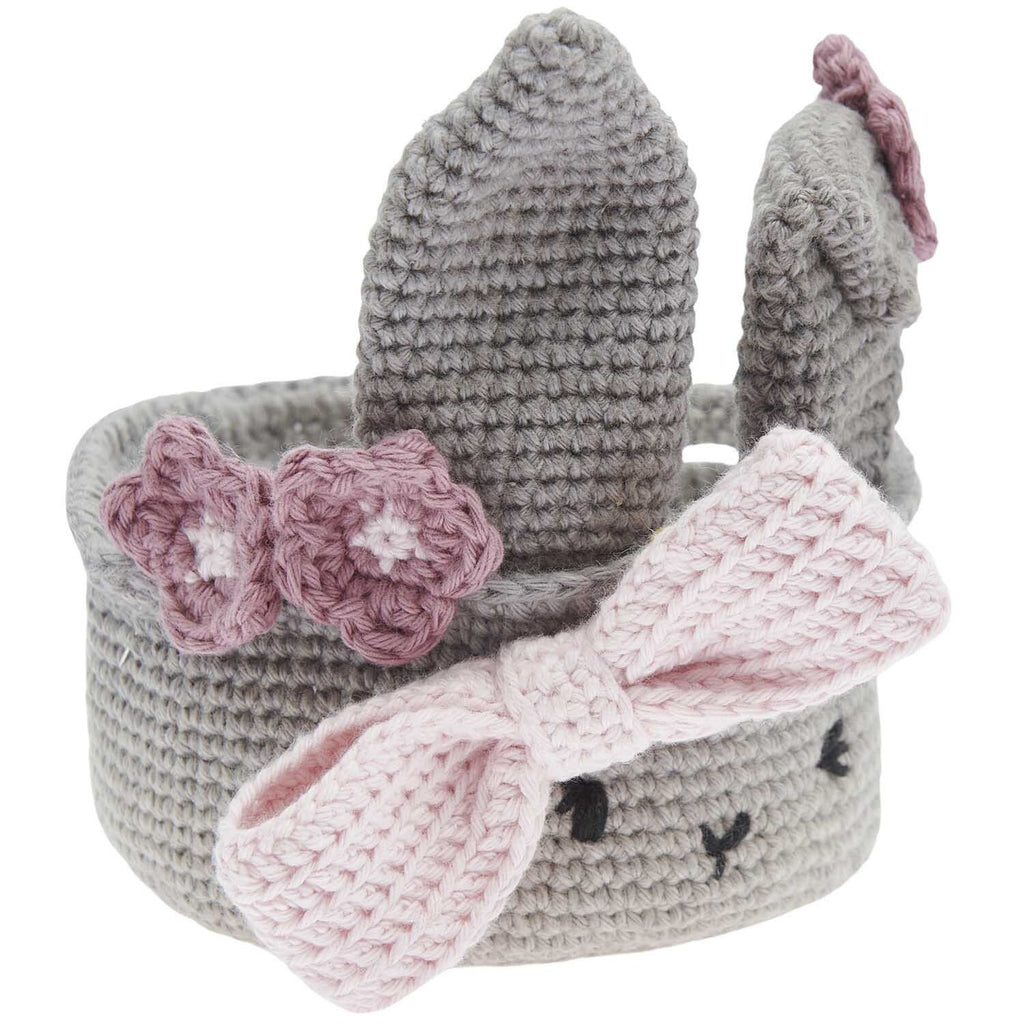 Caja del kit de tejido amigurumi de Rico Design mostrando un pequeño canastito de Pascua tejido a crochet con orejas de conejo y huevitos en tonos pastel.