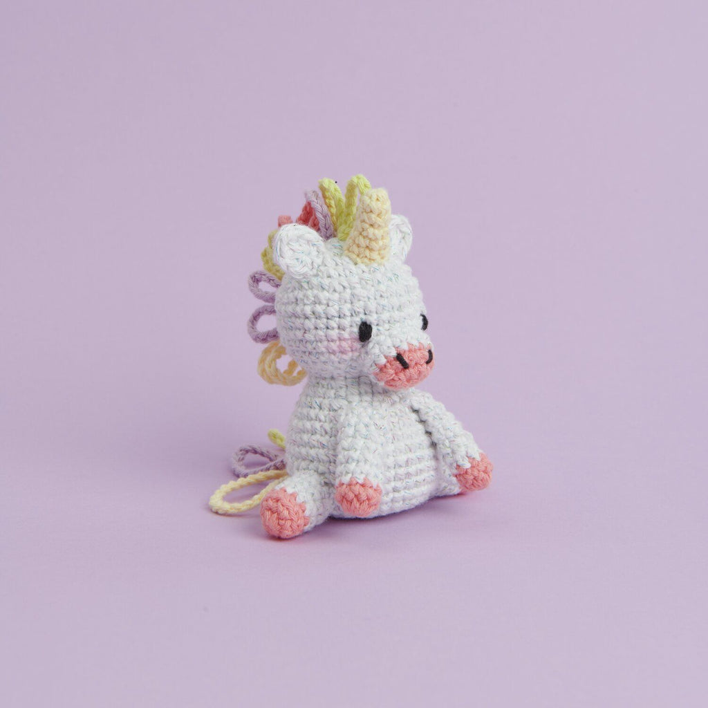 Kit de tejido Amigurumi Mini Easy de Rico Design mostrando un pequeño unicornio tejido a crochet en color blanco con detalles pastel.