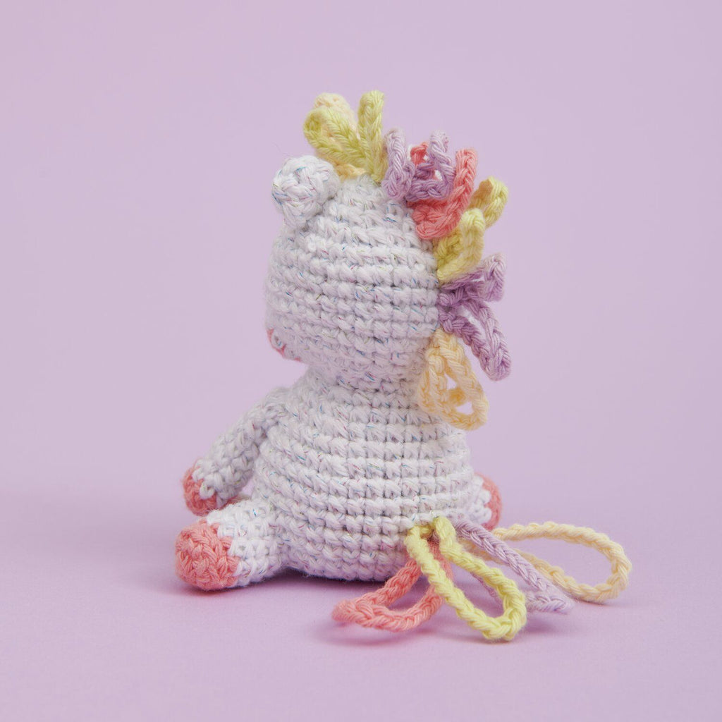 Kit de tejido Amigurumi Mini Easy de Rico Design mostrando un pequeño unicornio tejido a crochet en color blanco con detalles pastel.