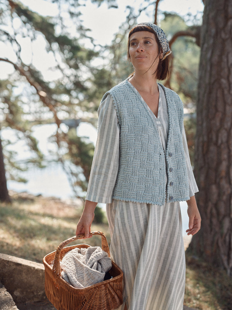 Laine Magazine 28 — cárdigan celeste con botones, entre los pinos