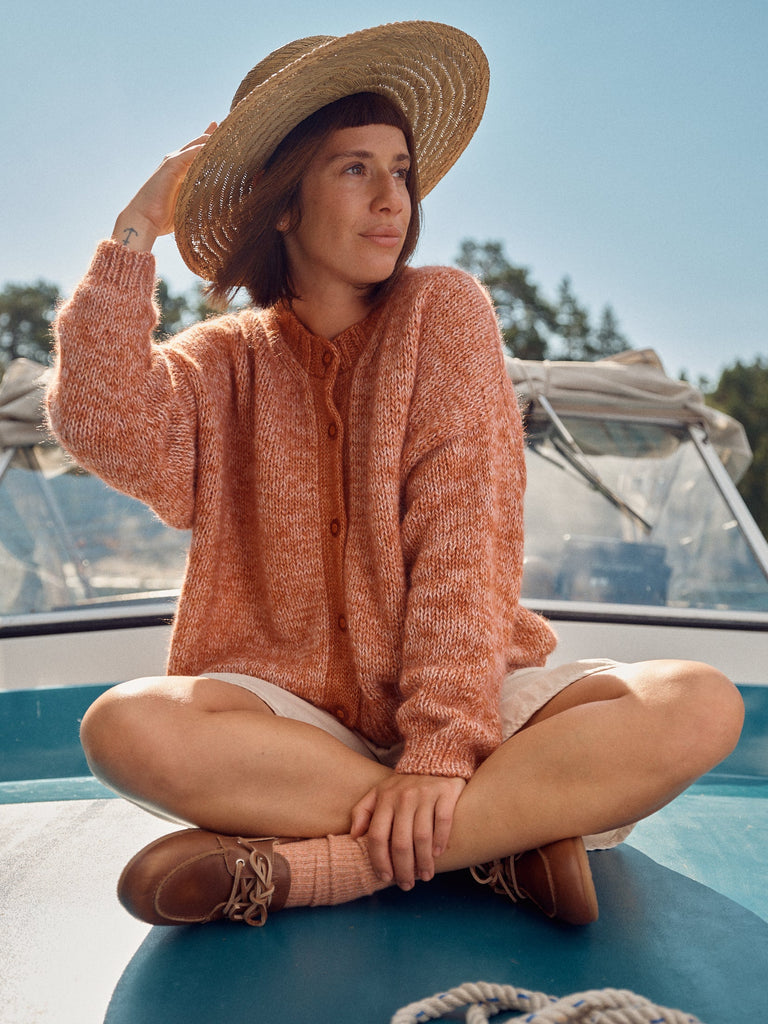 Laine Magazine 28 — cárdigan naranja en mohair, sentada en un bote