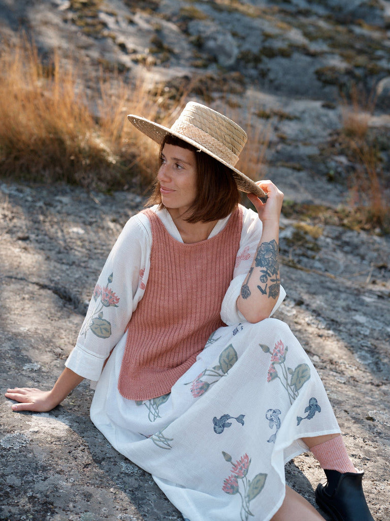 Laine Magazine 28 — chaleco rosa palo sobre blusa blanca, con sombrero de paja