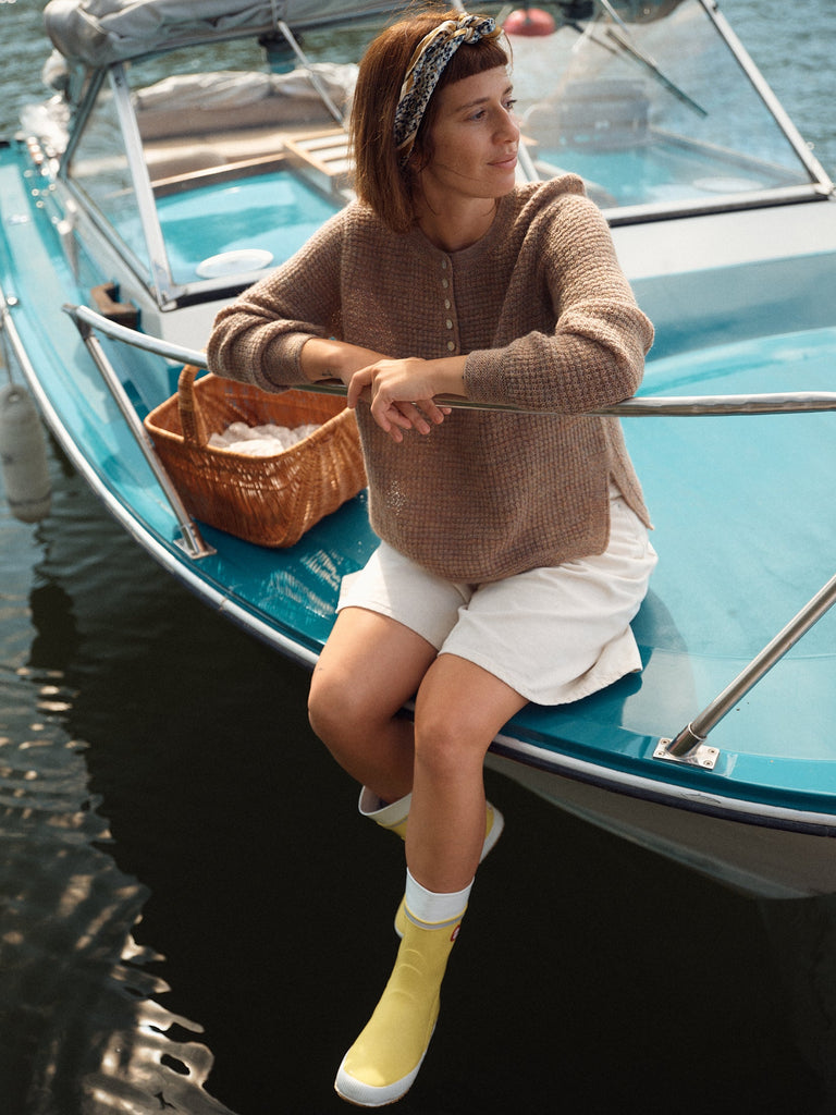 Laine Magazine 28 — suéter café en mohair con botones, al borde de un bote