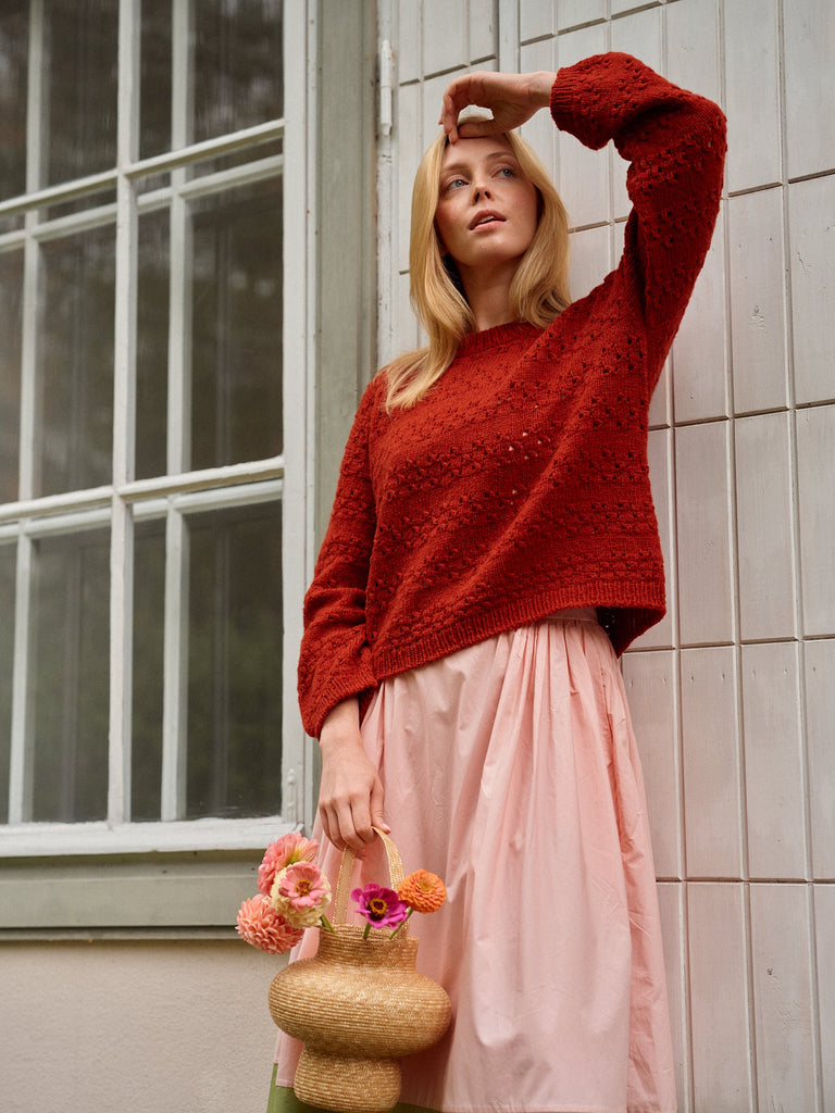 Laine Magazine 29 — suéter rojo teja con textura, sobre falda rosa