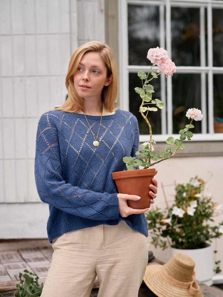 Laine Magazine 29 — top azul con motivo de rombos junto a la ventana