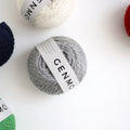 Ovillo de lana merino Genmou de la marca japonesa Daruma, de textura esponjosa tipo vellón en grosor DK, ideal para tejer chalecos ligeros a palillos.